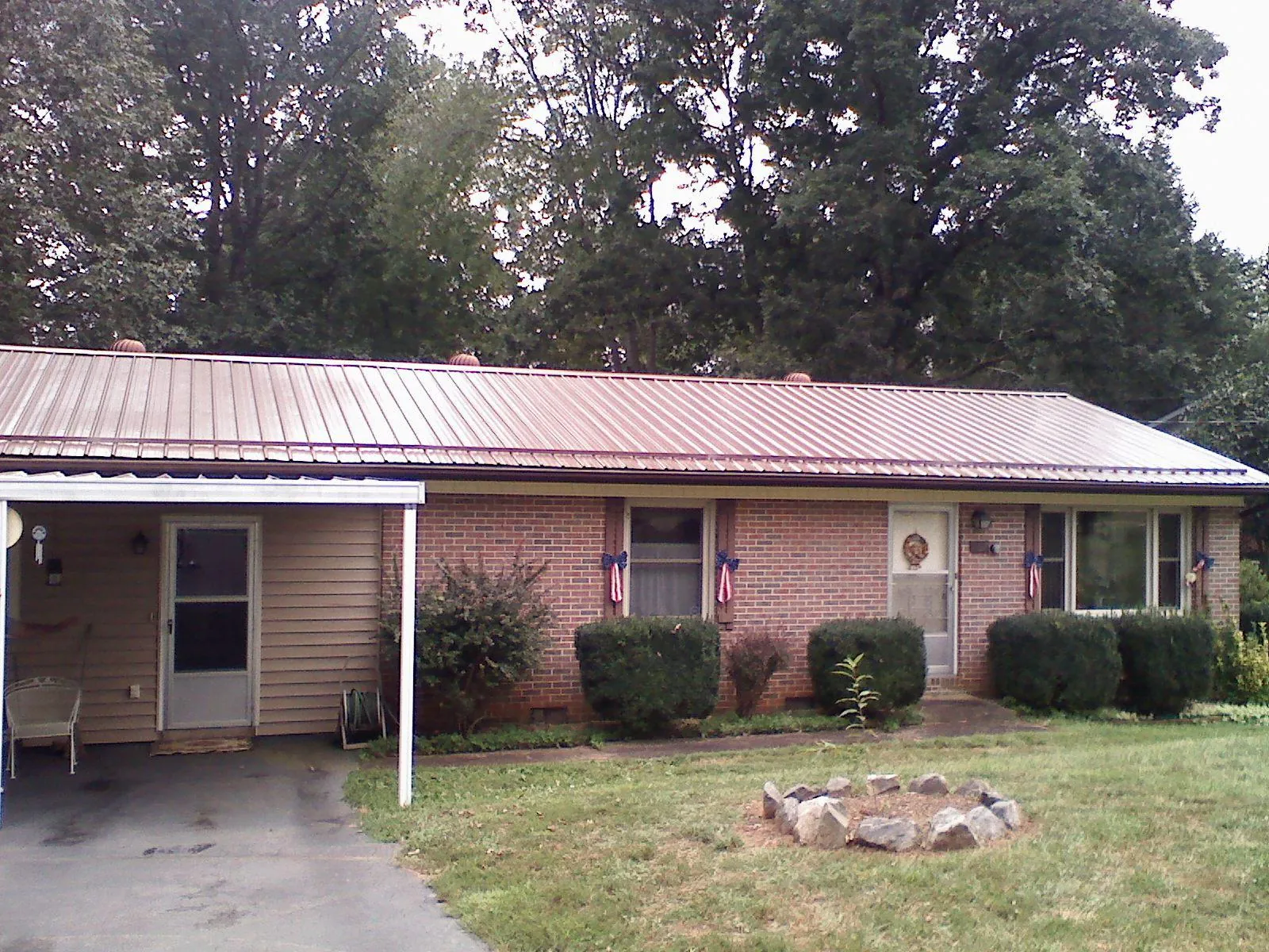 Bronze metal roof and carport on a brick ranch home — Roof Repair work by our crew in Serena